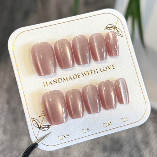 Rosa Nude Press-On Nägel mit Cat-Eye Effekt in Trapezform, glänzend und elegant gestylt auf einer Hand.